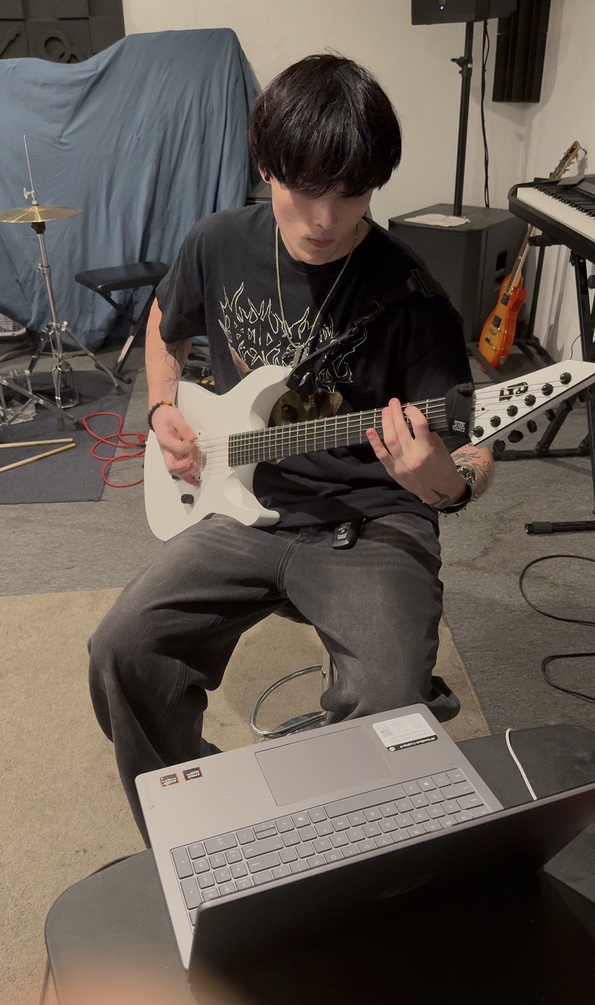 Ryan Dowell seated and playing a white seven-string guitar